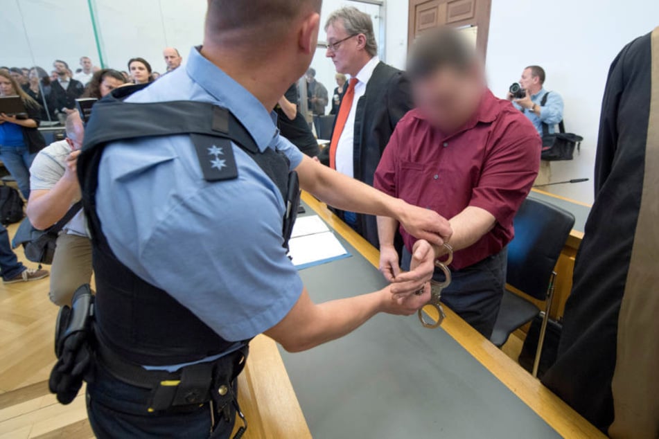 Der 42-jährige Angeklagte wird zur Anklagebank geführt (Archivbild vom 20.04.2018).