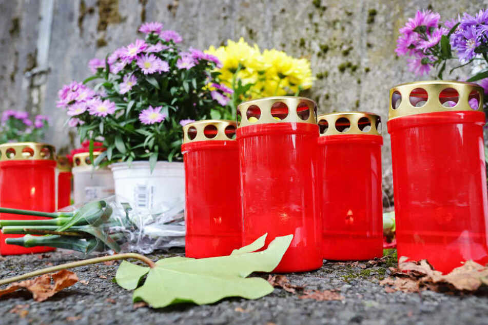 Kerzen und Blumen liegen in Freudenberg am Unglücksort (Archivbild).