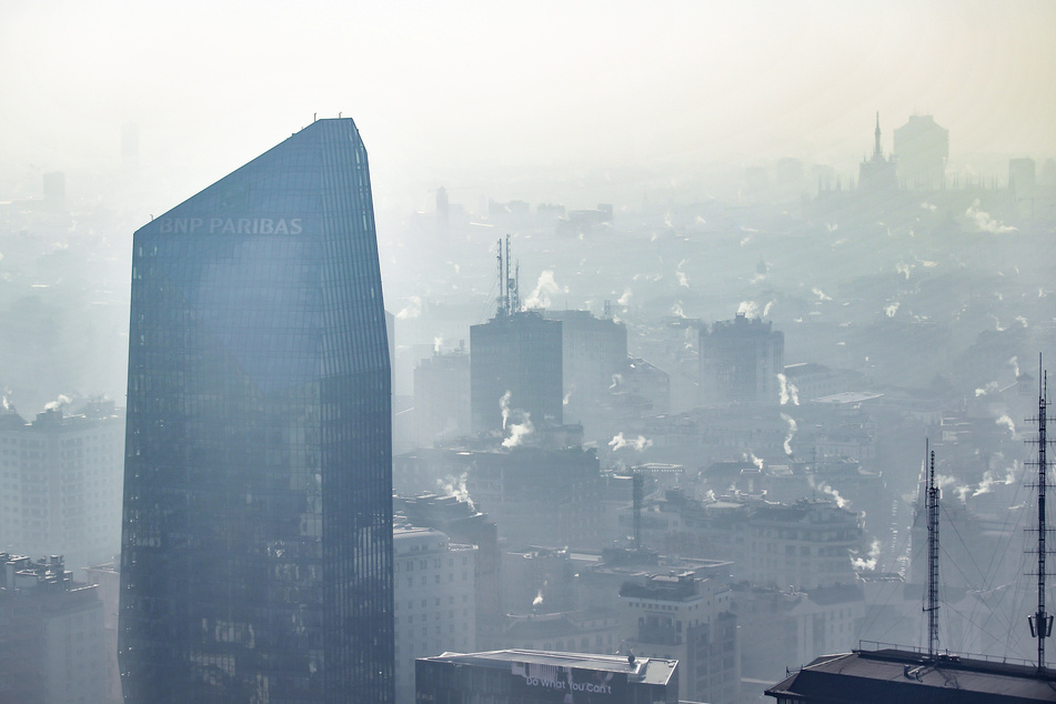 Dunst, Smog und der Rauch aus Schornsteinen hängen über der Innenstadt von Mailand.