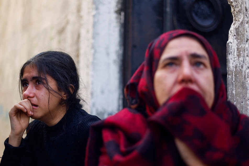 A Palestinian girl and woman react at the site of an Israeli strike on a house after a temporary truce expired, in Khan Younis in the southern Gaza Strip on December 1, 2023.