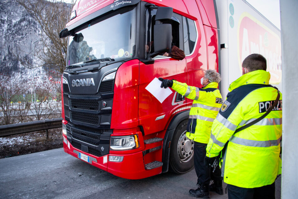 Zwei Bundespolizisten kontrollieren die Dokumente von aus Österreich kommenden LKW-Fahrern an der Autobahn A93 bei Kiefersfelden in Richtung Deutschland.