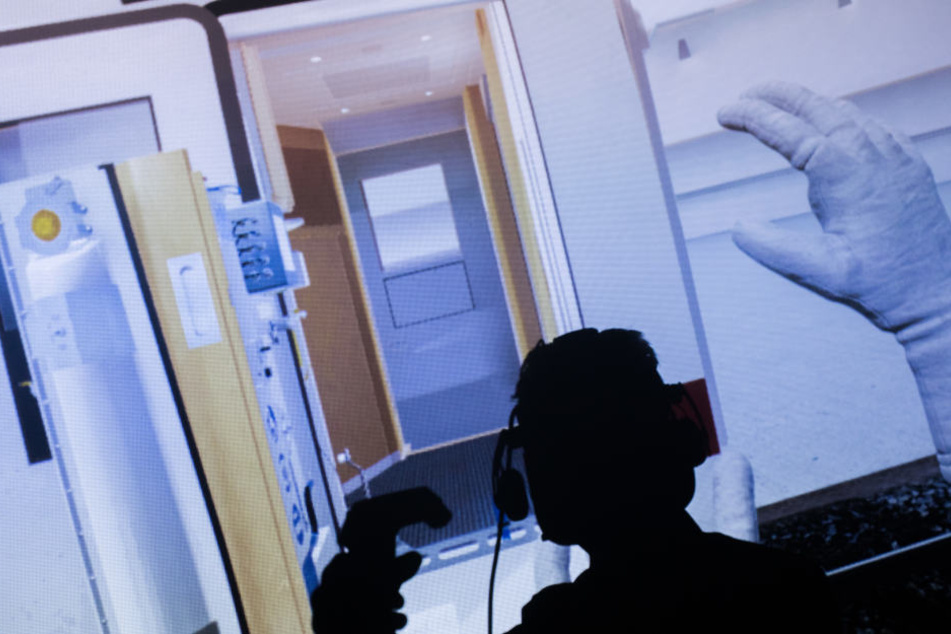 Ein Techniker zeigt bei einer Schulung mit Virtual Reality die Bedienung eines eingebauten Hublifts an den Türen eines ICE4 für Reisende mit Rollstuhl.