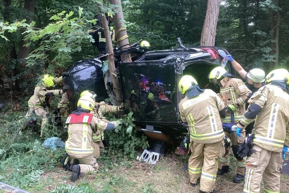 Einsatzkräfte der Berliner Feuerwehr bergen den verunfallten Wagen.