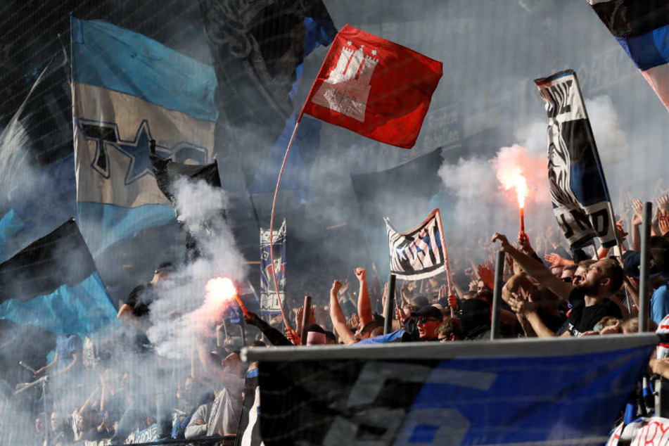 Fans schwenken HSV- und Hamburg-Fahnen und zünden Feuerwerk.