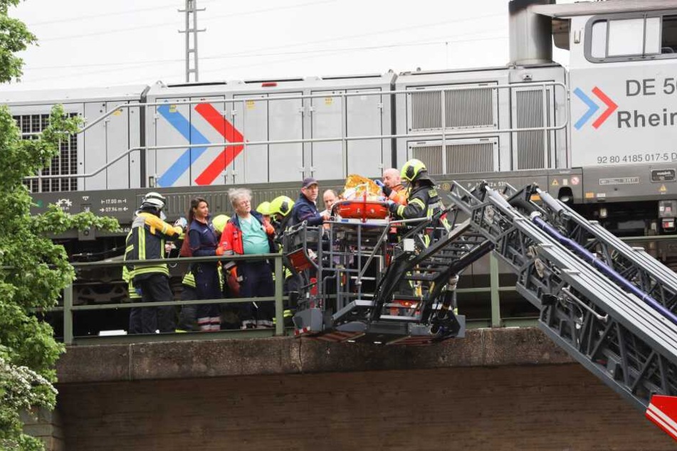 Rettungskräfte bei der Bergung des Tatverdächtigen an einer Bahnstrecke.