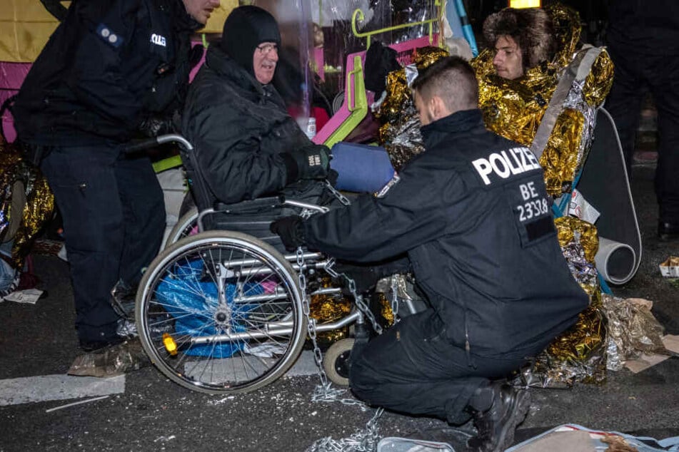 Polizisten schneiden am Potsdamer Platz die Ketten eines Aktivisten der Klimabewegung "Extinction Rebellion" mit einem Bolzenschneider durch.