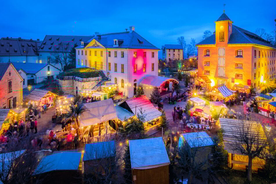 Der historische Weihnachtsmarkt auf der Festung Königstein erstrahlt in bunten Farben.