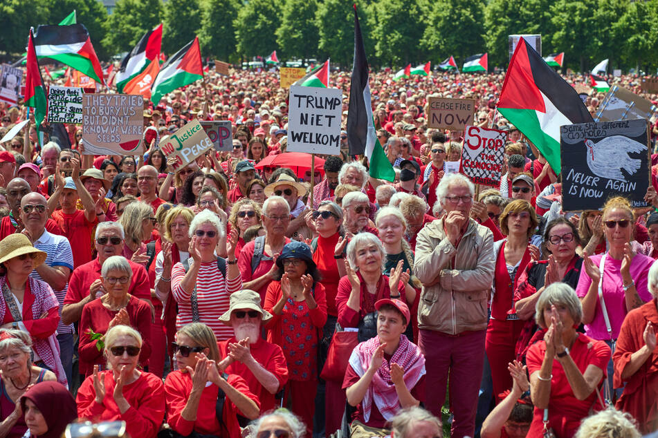 Rot gekleidete Demonstranten versammeln sich während einer Demonstration in Den Haag, Niederlande, und fordern von ihrer Regierung, mehr zu tun, um Israels Feldzug im Gazastreifen zu stoppen.
