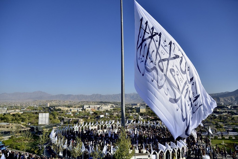 People gather for a hoisting ceremony of the Taliban flag on the Wazir Akbar Khan hill in Kabul, Afghanistan.