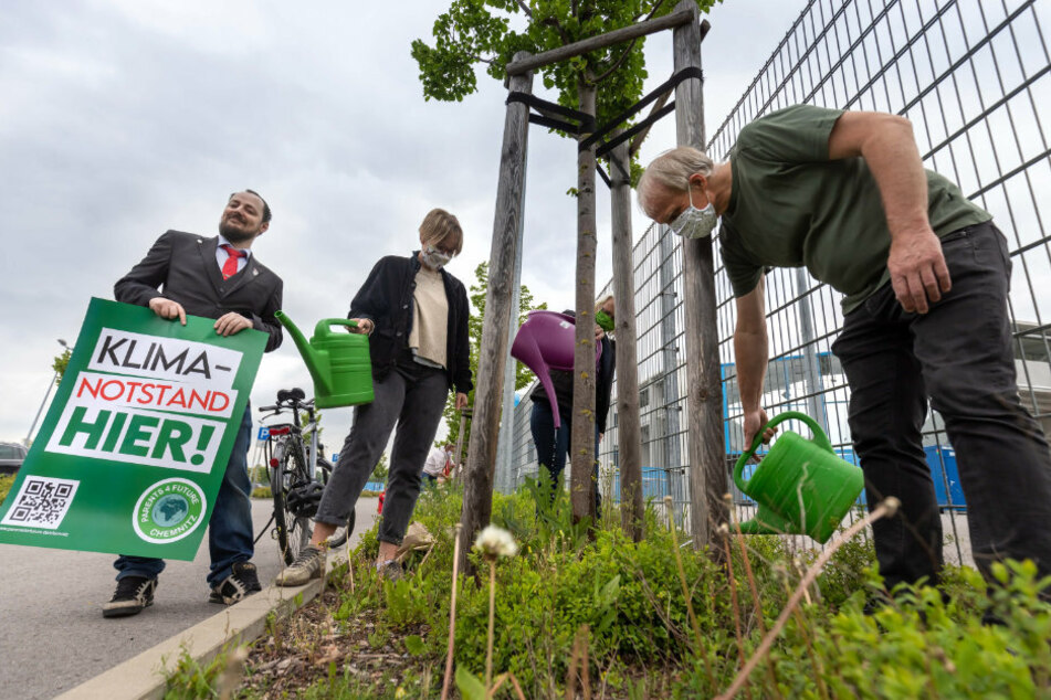 Tim Detzner (41, l.) und Sebastian Wittig (40) von Parents for Future Chemnitz füllen Wasser aus Kanistern in Gießkannen.