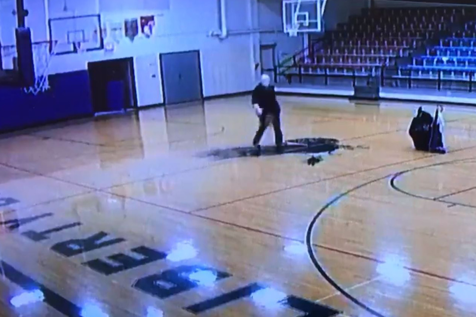 The janitor casually grabbed a basketball and shot a hoop over his shoulder.
