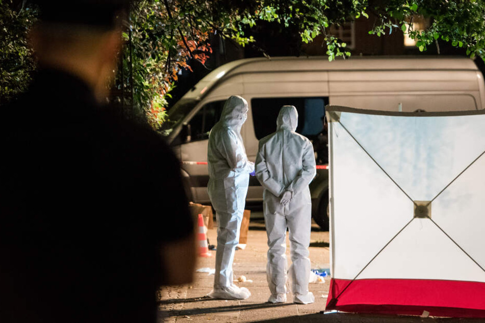 Polizisten in Schutzanzügen untersuchen im Stadtteil Lohbrügge den Tatort.