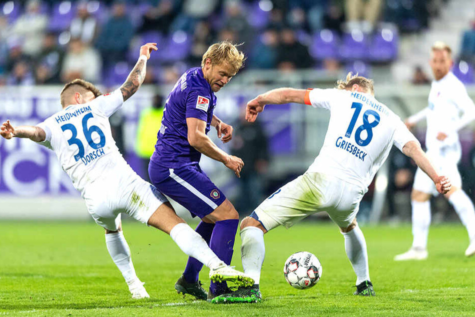 Ja, wer hat denn nun den Ball? Die Heidenheim Niklas Dorsch und Sebastian Griesbeck nehmen Aues Jan Hochscheidt in die Zange.