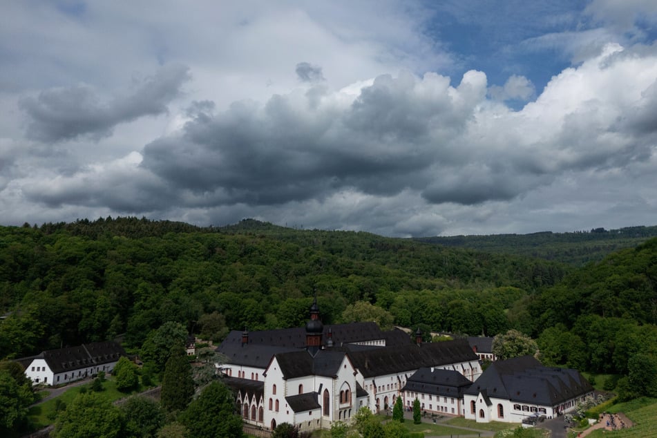 Regenwolken über Kloster Eberbach: Vor allem am Montag und am Mittwoch sind auch Gewitter mit Starkregen und Hagel in Hessen möglich.