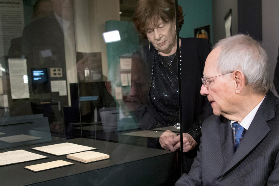 Die KZ-Überlebende Sheindi Ehrenwald und Wolfgang Schäuble (CDU), Bundestagspräsident, stehen bei der Eröffnung der Ausstellung "Deportiert nach Auschwitz - Sheindi Ehrenwalds Aufzeichnungen" im Deutschen Historischen Museum neben einer Vitrine.