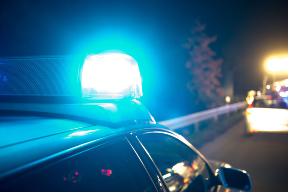 Ein Polizeiwagen fährt mit Blaulicht durch die Nacht (Symbolbild).