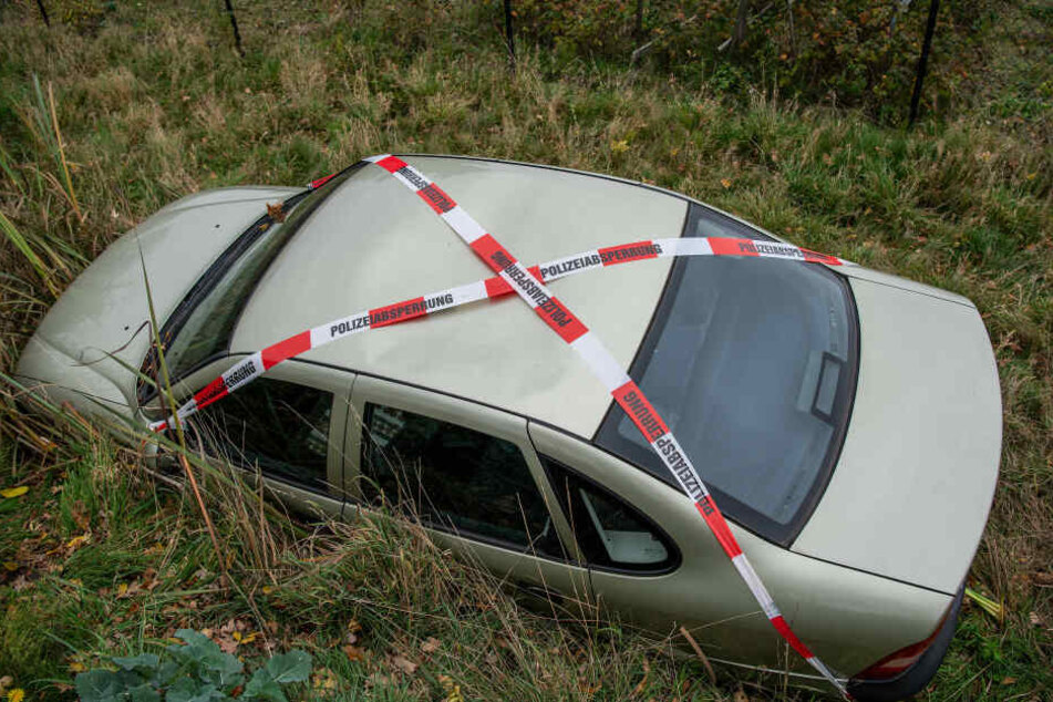 Von der Straße aus ist nur das Dach des Opel zu sehen.