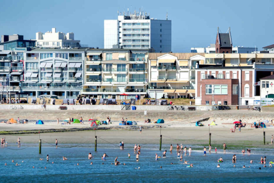 Touristen baden am Strand der Nordsee-Insel Norderney.