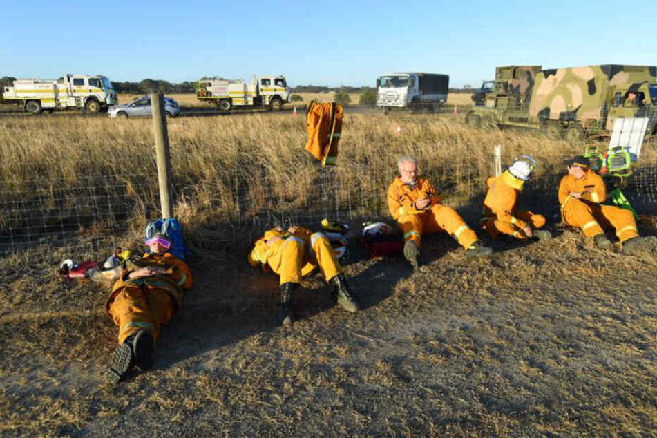 Freiwillige Helfer vom NSW State Emergency Service (SES) ruhen sich auf dem Flughafen Kangaroo Island, südwestlich von Adelaide, aus.