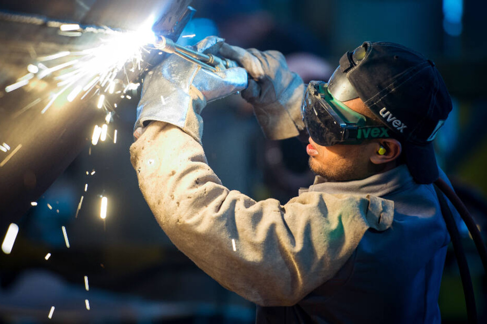 Die Wirtschaft will Fachkräfte nach Deutschland locken, die wie dieser Einwanderer aus Somalia zum Beispiel in der Industrie als Schweißer arbeiten.