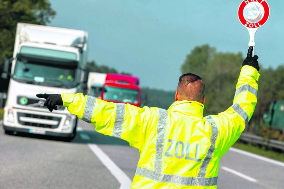 Ein Zöllner lotst einen Lkw von der Autobahn zur Kontrollstelle. Ein Großteil des illegal eingeführten Tabaks wurde in Lastwagen entdeckt.