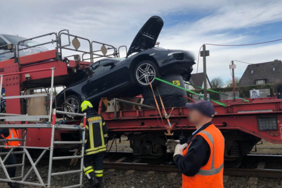 Einsatzkräfte untersuchen den verunfallten Porsche auf dem Sylt-Shuttle.