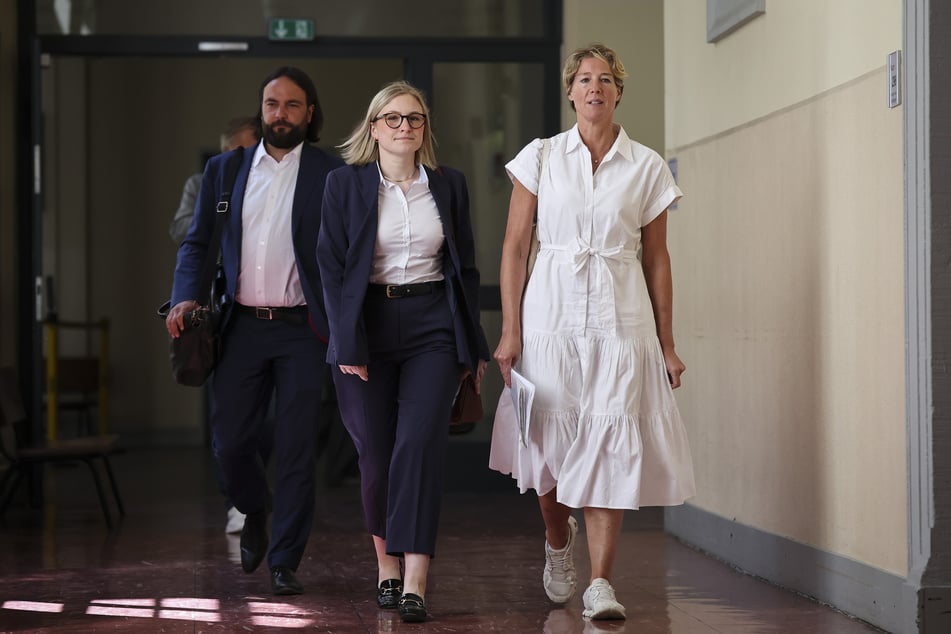 Christina Block (r.), Ingo Bott und Rechtsanwältin Paula Wlodarek (m.) gehen nach der Mittagspause zurück in den Gerichtssaal.