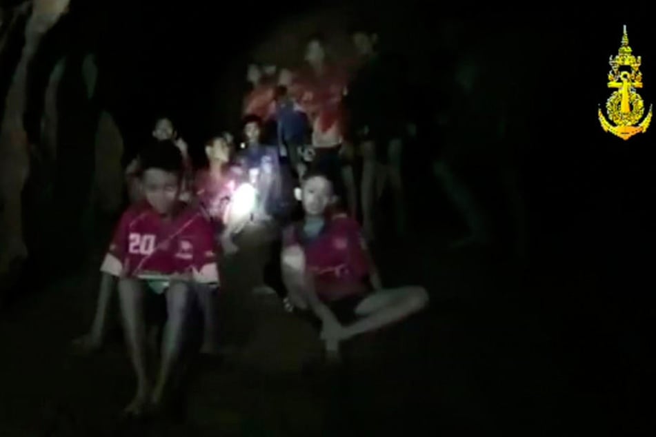 Ein Video-Standbild des Thai Navy Seal zeigt die vermissten Jugendfußballer und ihren Trainer, nachdem sie in einer Höhle gefunden wurden.