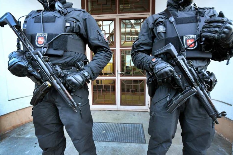 Bewaffnete Polizeibeamte sichern einen Eingang zum Oberlandesgericht.