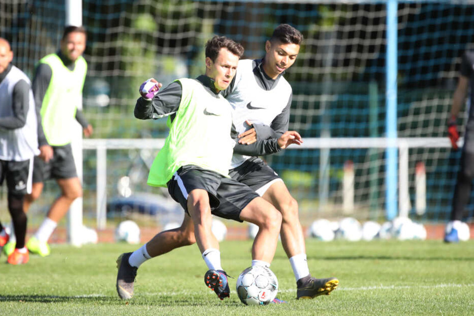 Clemens Fandrich (l.) beim Training im Zweikampf mit John Patrick Strauß. An seinem rechten Arm ist die lila Schiene erkennbar.