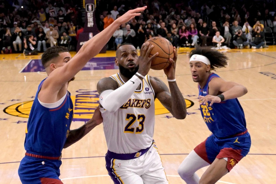 The Los Angeles Lakers' LeBron James (c.) drives past Denver Nuggets forward Michael Porter Jr. (l.) and forward Zeke Nnaji (r.) to score his 40,000th career point at Crypto.com Arena on Saturday night.