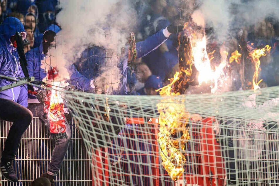 Maskierte Herthafans zünden Union T-Shirts an.
