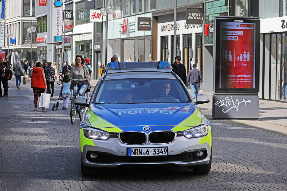 Eine Polizeistreife fährt durch eine Kölner Fußgängerzone.