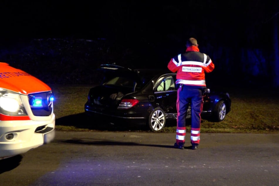 Ein Rettungssanitäter steht vor einem der Unfallautos.