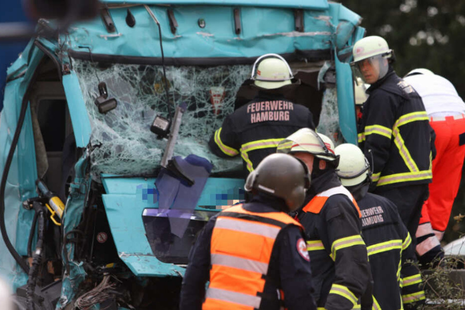 Rettungskräfte bergen den Fahrer aus der zerstörten Kabine.
