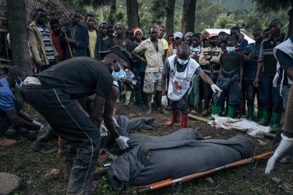 Freiwillige des kongolesischen Roten Kreuzes wickeln die Leichen von Menschen, die bei den schweren Überschwemmungen ums Leben gekommen sind.
