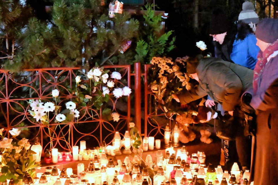 Blumen und Kerzen werden am Ort eines Brandes niedergelegt, bei dem fünf Mädchen gestorben sind.