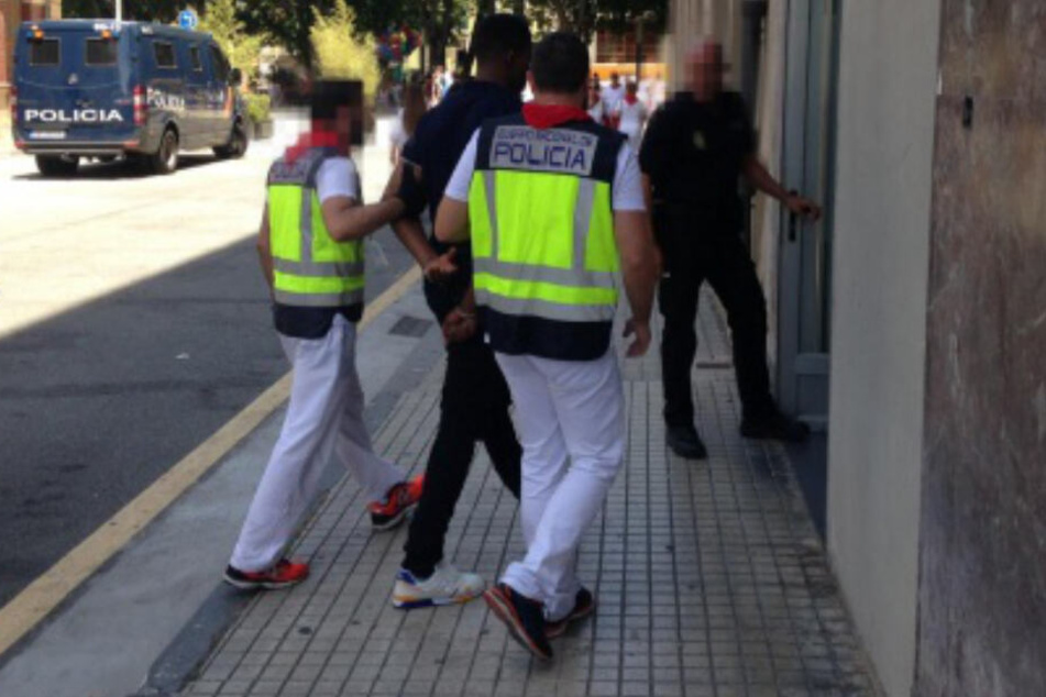 Beamte der spanischen Nationalpolizei bringen den Gefangenen zur Polizeiwache bringen.