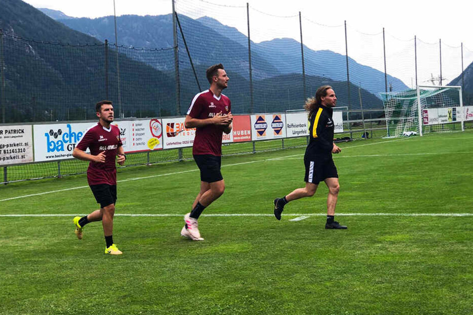 Justin Löwe (l.) und Florian Ballas (M.) drehen mit Reha-Coach Tobias Lange erste Runden auf dem Platz.