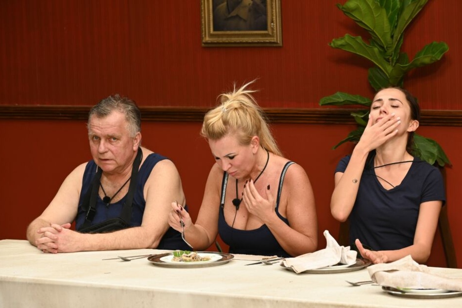 Während bei der Essprüfung ein neuer Kotzrekord aufgestellt wurde, durfte Verkehrs-Günni der Wendler-Ex Claudia Norberg (M.) und Anastasiya Avilova (r.) aufgrund seines ausgehandelten Vertrages beim Würgen zusehen.