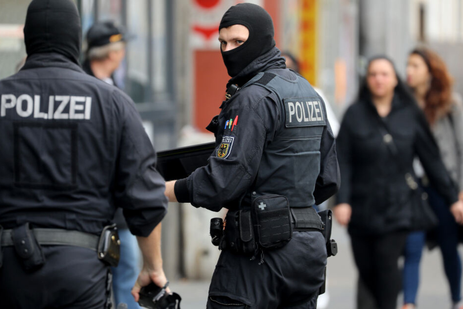 Bundespolizisten gehen zu einem Wohnhaus in Köln.
