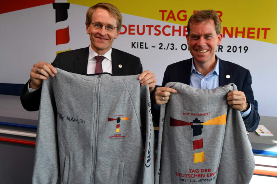 Freiwillige Helfer werden diese Jacken tragen, die Daniel Günther (CDU, links), Ministerpräsident von Schleswig-Holstein und Ulf Kämpfer (SPD), Kieler Oberbürgermeister, präsentieren.