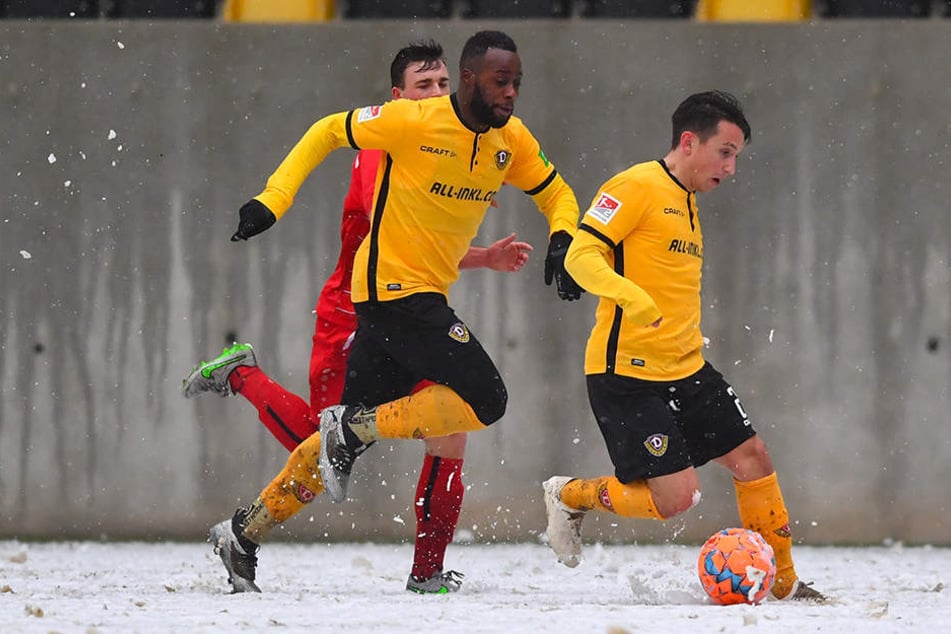 Dynamos Baris Atik (r.) führt den Ball auf dem schneebedecktem Geläuf und wird von Erich Berko (M.) überlaufen.