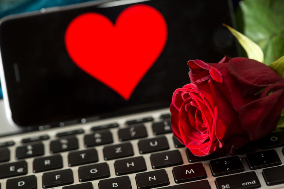 Eine Rose liegt auf einer Computertastatur.