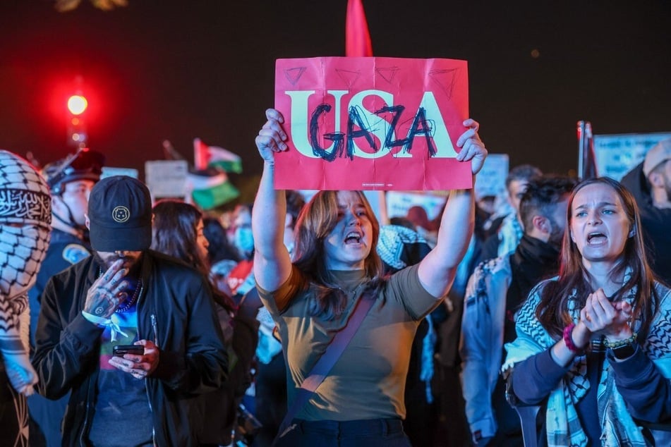 A protester holds up a sign reading "USA" with "Gaza" written on top, as demonstrators rally near the Washington Monument during Vice President Kamala Harris' speech at the Ellipse, just south of the White House, on October 29, 2024.