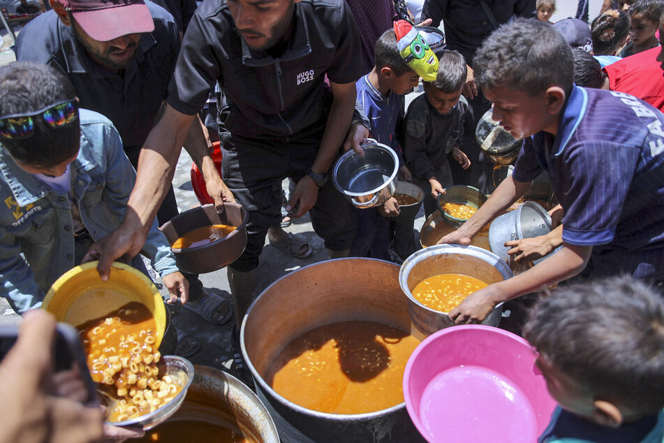 Children line up to receive food at a UN Relief and Works Agency for Palestine Refugees (UNRWA) school in the Jabalia camp for Palestinian refugees in the northern Gaza Strip on Monday.