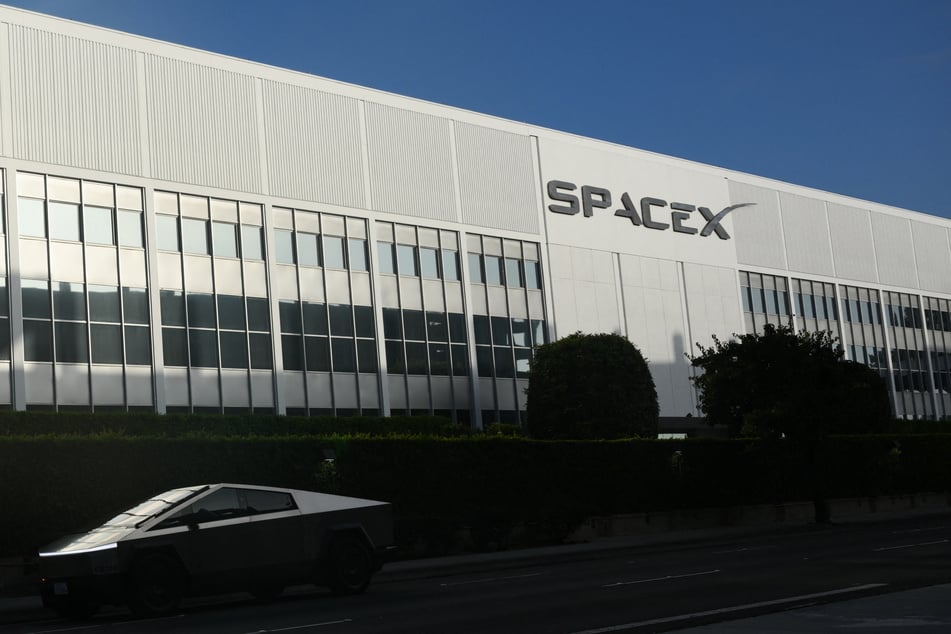The SpaceX logo is seen on a building as a Tesla Cybertruck drives past a Space Exploration Technologies Corp. facility in Hawthorne, California, on June 9, 2026.