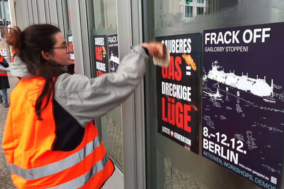 Klima-Vorkämpferin Lilli Gomez (24) kleistert die Fassade des Energie-Riesen TotalEnergies mit Plakaten zu.