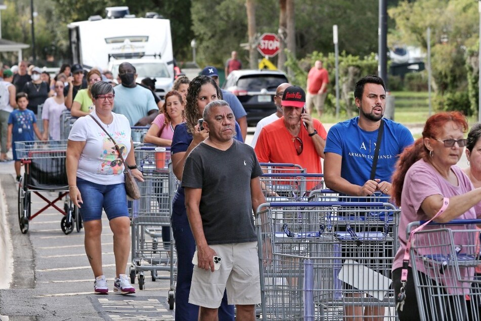 Shoppers wait in line outside a retail warehouse in Kissimmee, Florida, as people rush to prepare for Tropical Storm Ian.
