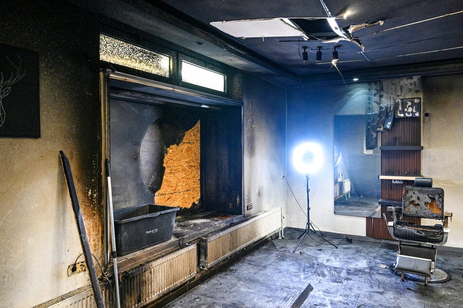 Decke, Wände und Friseurstuhl sind durch den Brandanschlag verkohlt.